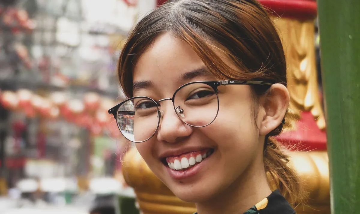 A smiling young woman with glasses